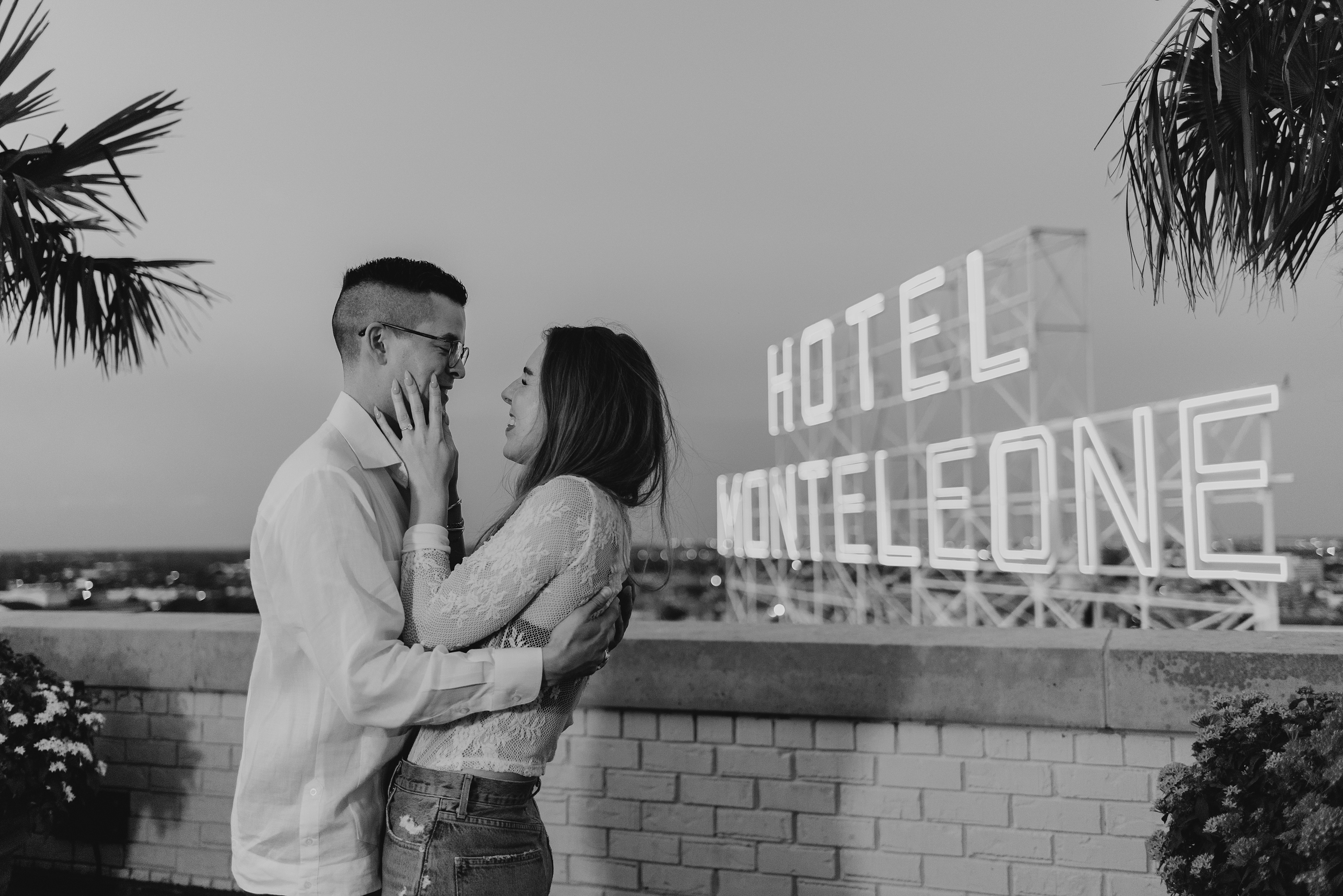 black and white photo of couple embracing each other in front of hotel monteleone